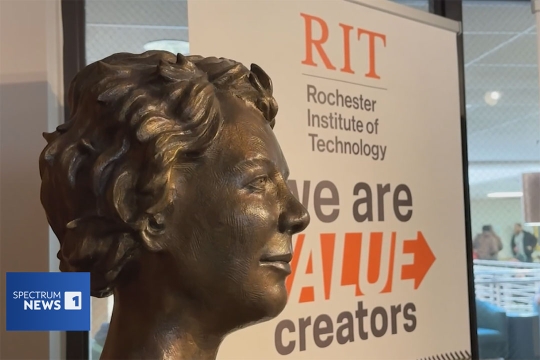 screenshot of a sign for R I T in the background and bust of Kate Gleason in the foreground.