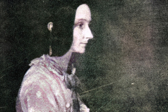 a colorized image of a woman from the 18 hundreds.