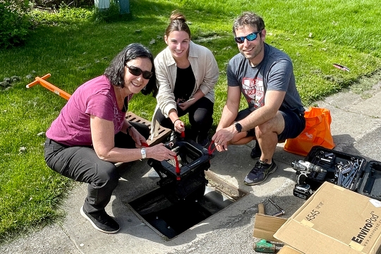 Three people pose around a Littatrap.