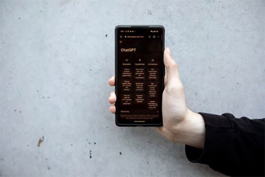 person holding a smartphone with Chat G P T on the screen.