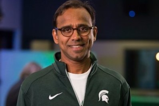 Man with glass and green jacket. 