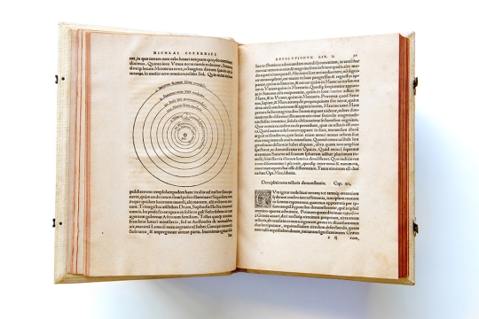 the aging text of Nicolaus Copernicus' De Revolutionibus Orbium Coelestium is shown open to middle pages.