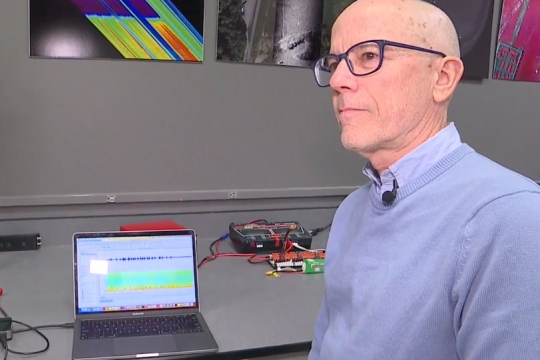 Tony Vodacek is shown talking to WHAM-TV sitting in front of his laptop that is displaying audio files.