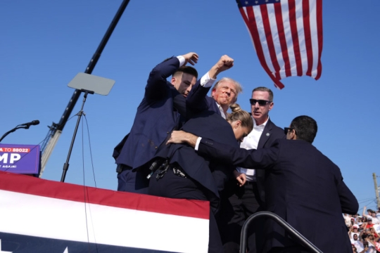 Republican presidential candidate former President Donald Trump gestures as he is surrounded by U.S. Secret Service agents as he leaves the stage at a campaign rally on Saturday July 13 in Butler, Pa. 