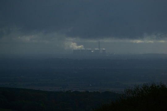 smoke from gas emissions is shown in the air with a factory in the background.