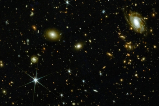 A screenshot of a section of sky in the COSMOS-Web interactive catalog showing a scattering of bright spots, stars and galaxies, against the dark black backdrop of the universe.