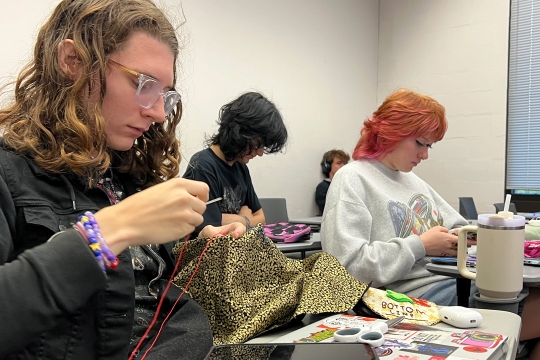 students create patches and buttons in a classroom.