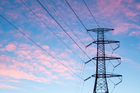 a electricity pole appears with the background of a blue and pink late day sky.