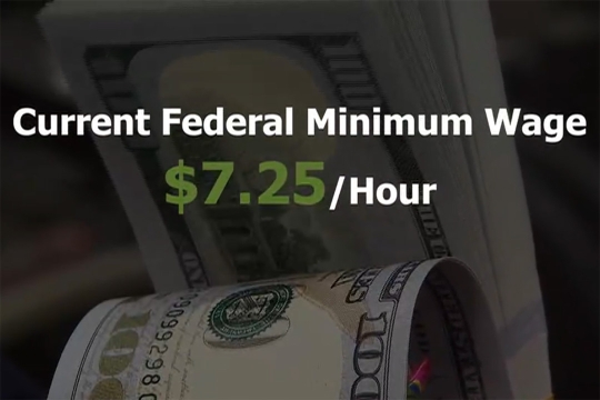 A text graphic that reads Current Federal Minimum Wage $7.25 per hour. The text is overlayed on a close up image of one hundred dollar bills.