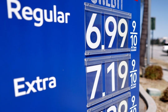 a sign at a gas station showing pricing for the day