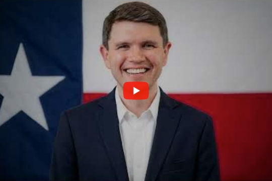 a headshot of representative James Talarico in front of hte Texas state flag with a play button in the middle of the image, indicating it is a video.