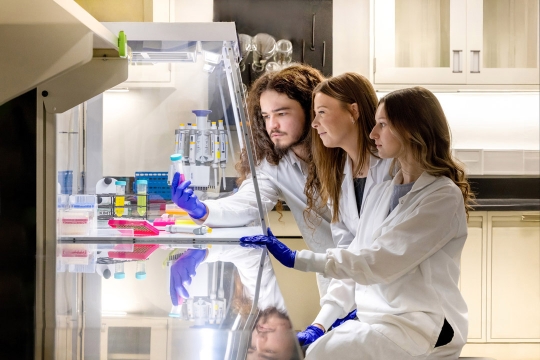 Assistant Professor Elle Barnes, center, works with students William Goyette, left, and Lilly Rennie, right, in the MEGA Lab on RIT’s campus. 