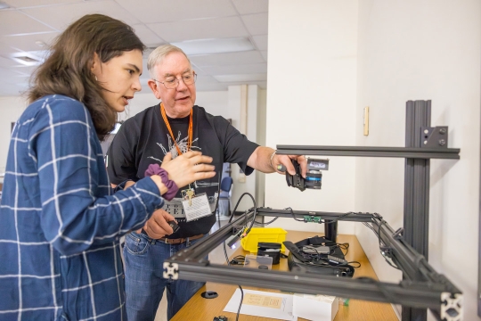 Tom Rieger, right, works with graduate student Lilli Kelley, left, to demonstrate imaging technology developed by the Cultural Heritage Imaging Lab during the MISHA Summer Seminar educational workshop.