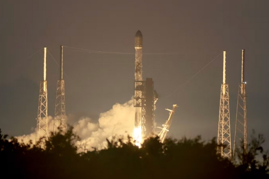 A SpaceXFalcon 9 rocket lifts off a launching pad