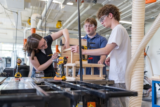 students work together in a woodworking shop