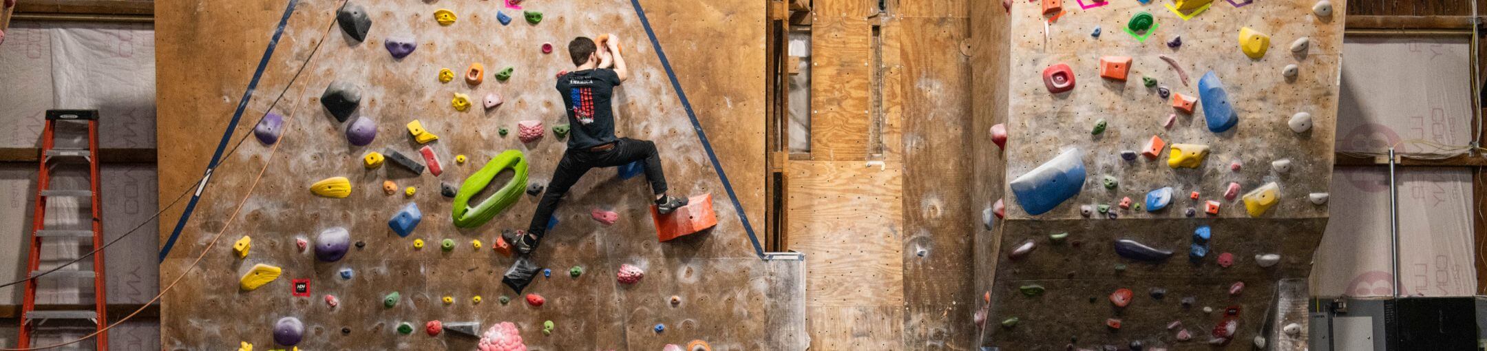 A student climbing one of the walls in the Red Barn.