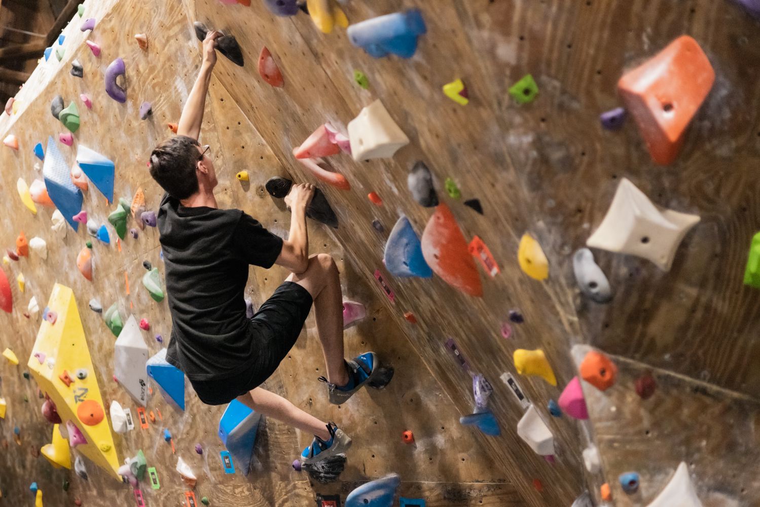 a student rock climbing on a climbing wall at the Red Barn at RIT