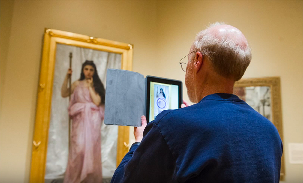 Man taking a photo of a painting at the art museum.