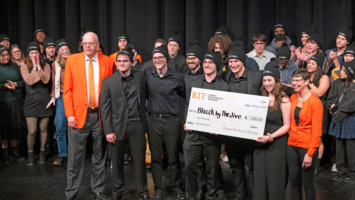 A 2025 photo of students their check for $1,000 being awarded by President Munson and Nancy Munson. 