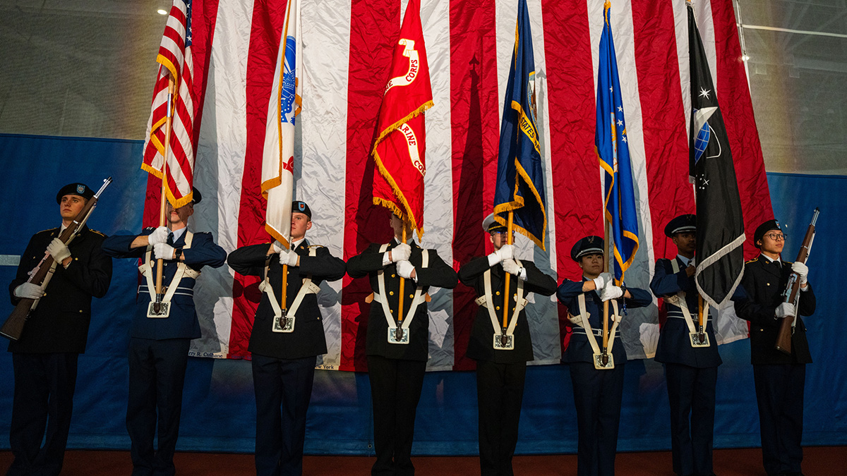 Service members holding flags of their branches.