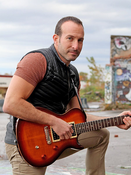 Portrait of Seth Sealfon with a guitar.