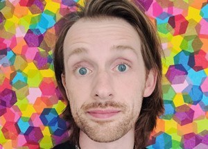 Headshot of a man with a multicolor background.