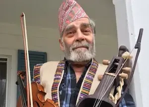 A man holding multiple instruments.