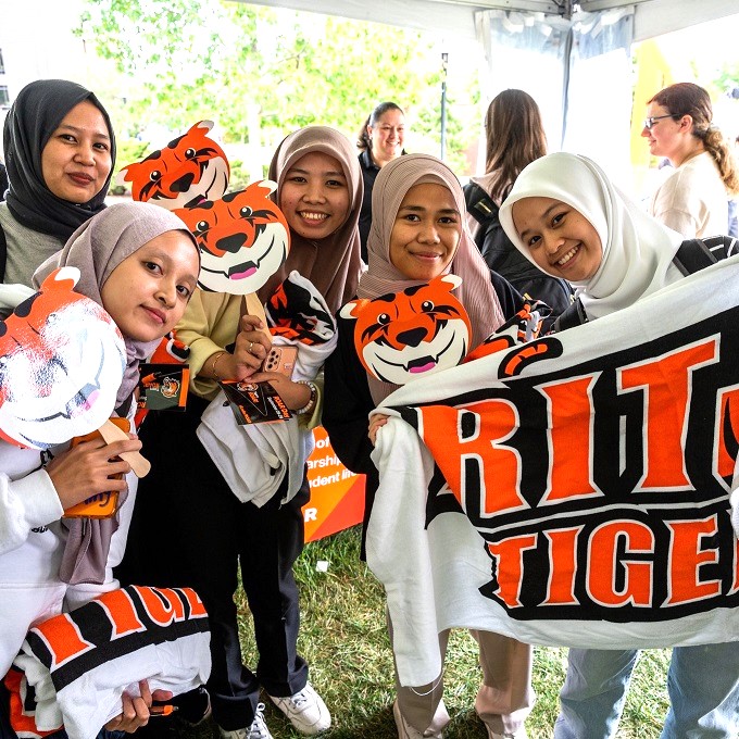 Students posing with Ritchie masks and banner