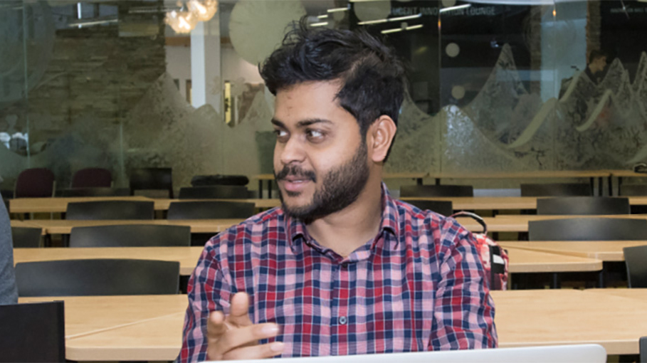 3 students sitting at laptops, having a meeting.