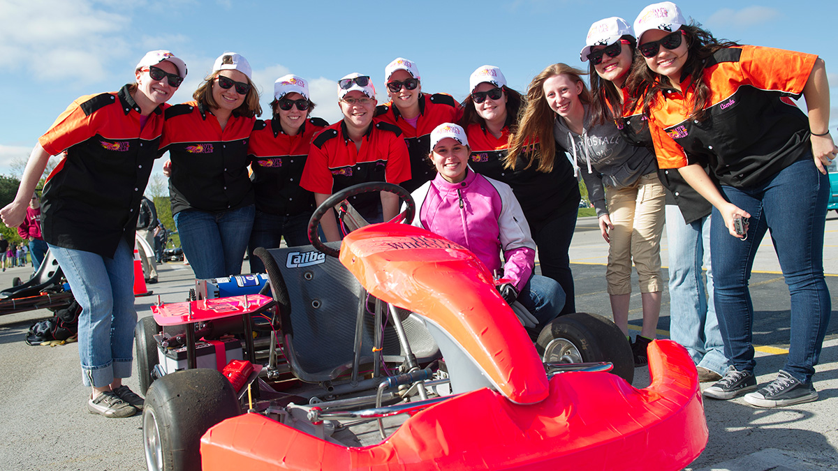 Students posing behind a student-built race car.