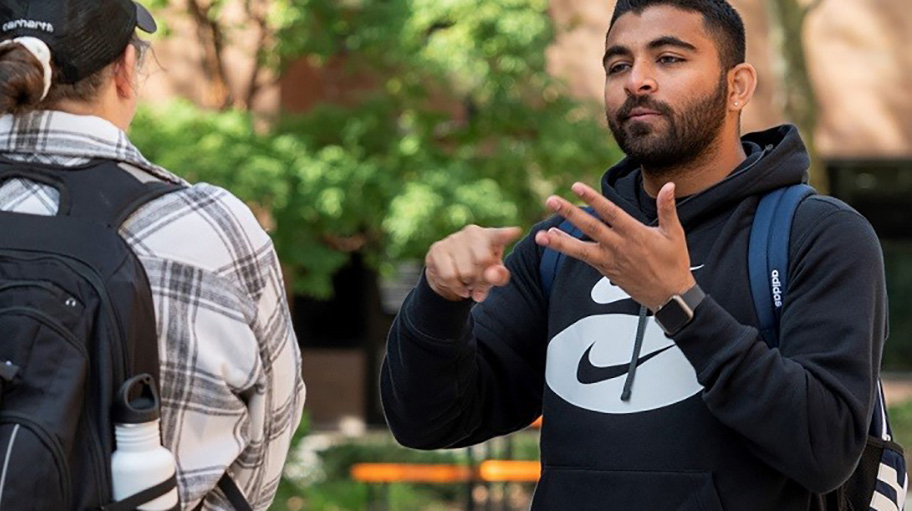 Students signing with ASL on campus.