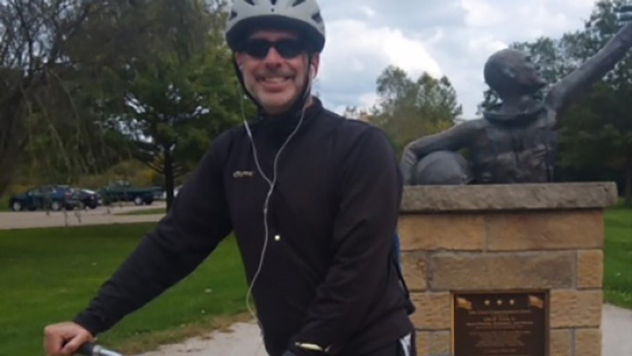 man posing for a photo on a bike.