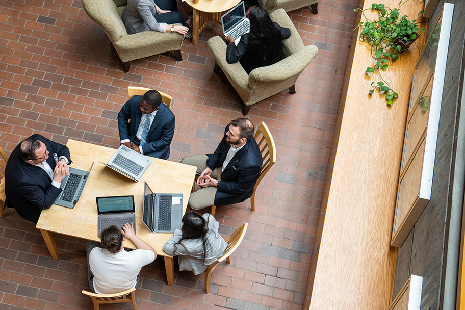 People wearing suits, speaking to each other.