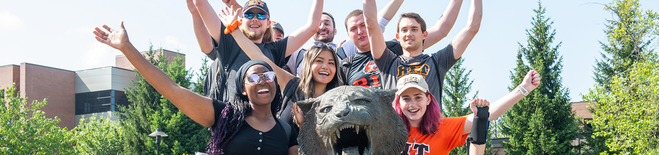 Students pose for a group photo with RIT tiger statue