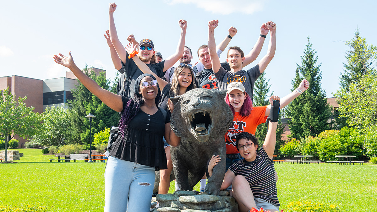 Students pose for a group photo with RIT tiger statue