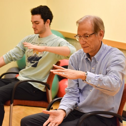 Two people doing seated Tai Chi