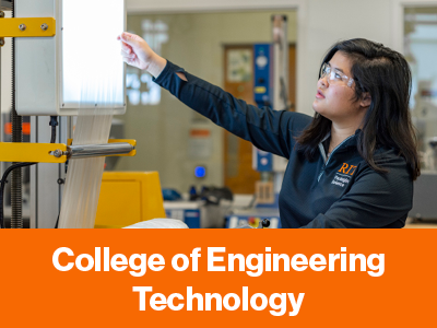 A student in safety glasses and an RIT jacket reaches toward lab testing equipment.
