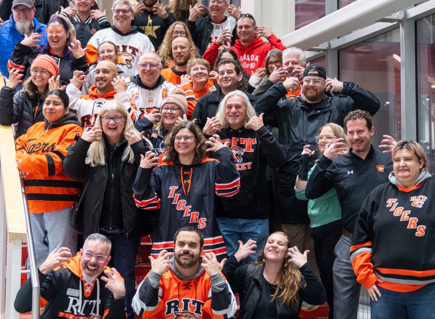 Group of people making the tiger sign with their hands