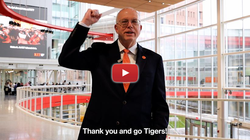 a man in a suit holding up his fist with a YouTube play button over it