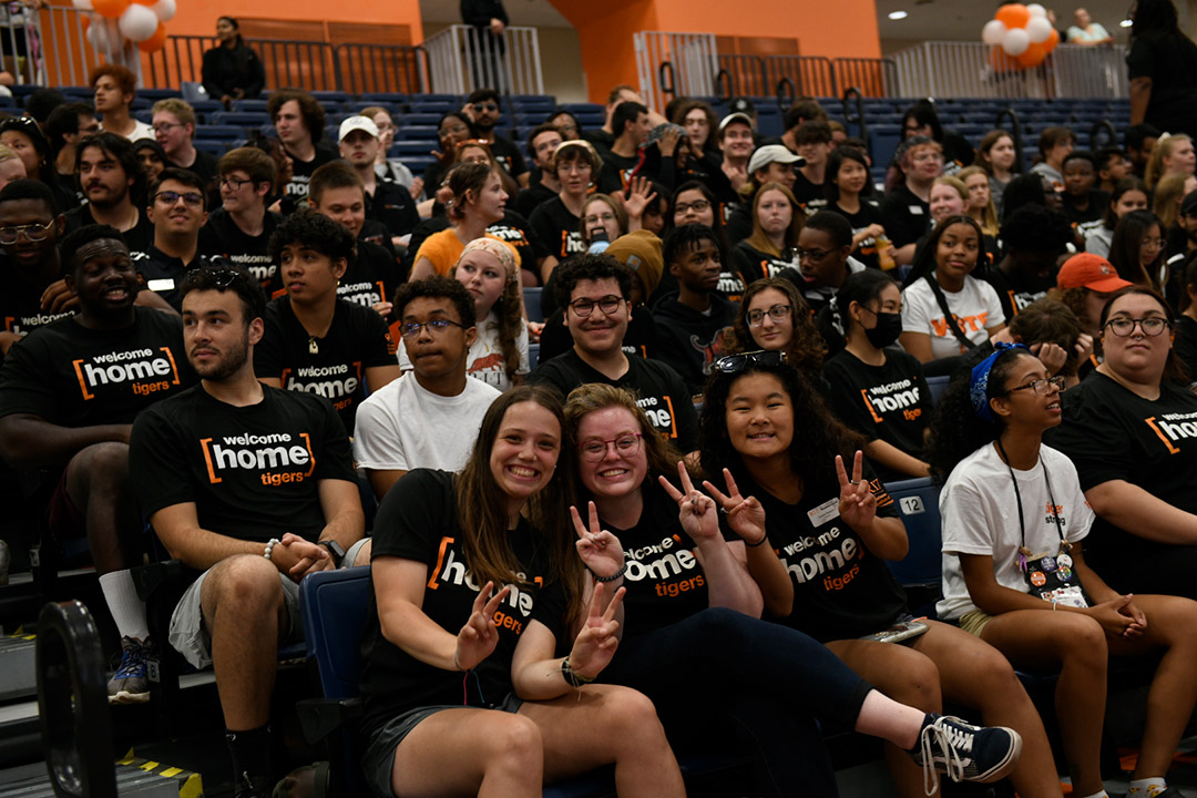 Students sitting in the Gordon Field House, smiling for the camera.