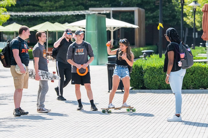 Students outside, with longboards.