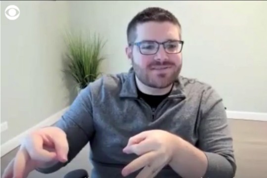screenshot of person on a news interview using sign language.
