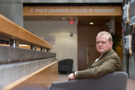 person sitting in chair in lobby of the Saunders College of Business.