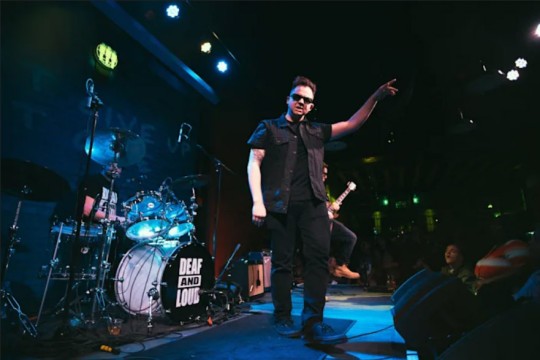 musician pointing to the crowd from a stage.