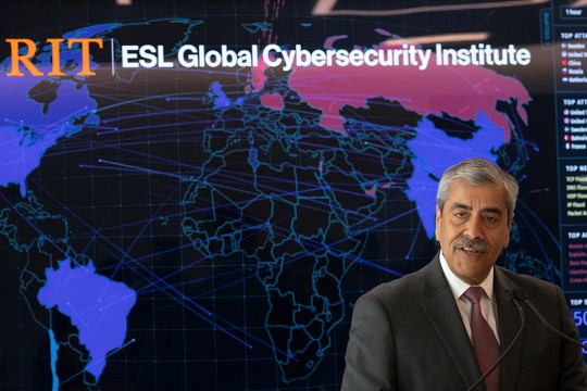 man standing in front of a map of the world with the words RIT ESL Global Cybersecurity Institute.