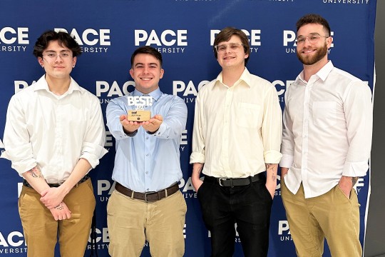 four advertising and public relations students stand together at the conference posing with their new award