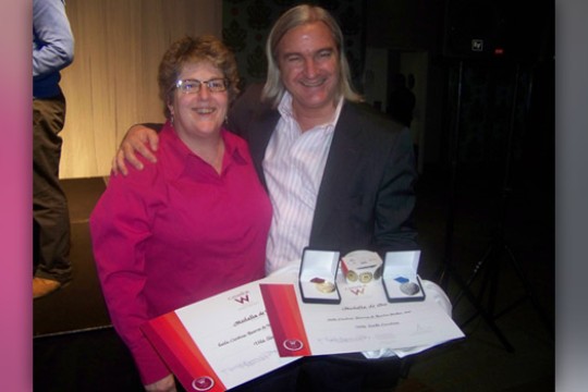Two people posing with award
