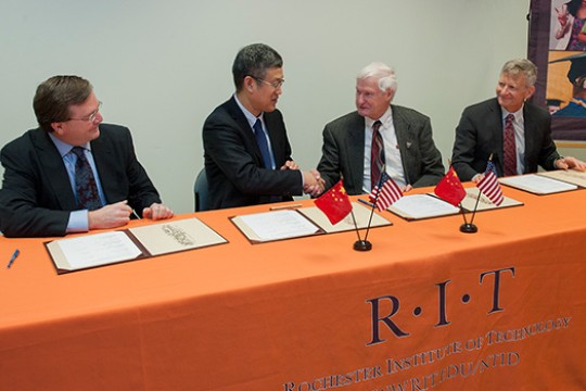 People shaking hands at table with RIT Table Sheet