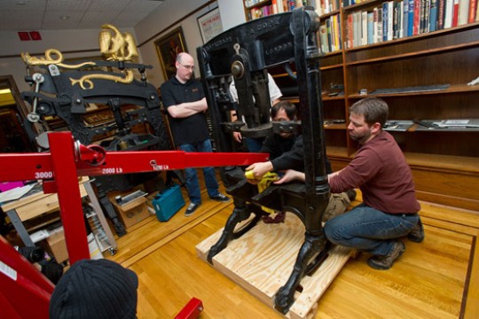 People working on a large letterpress machine.