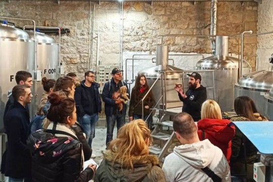 group of people touring a brewery.